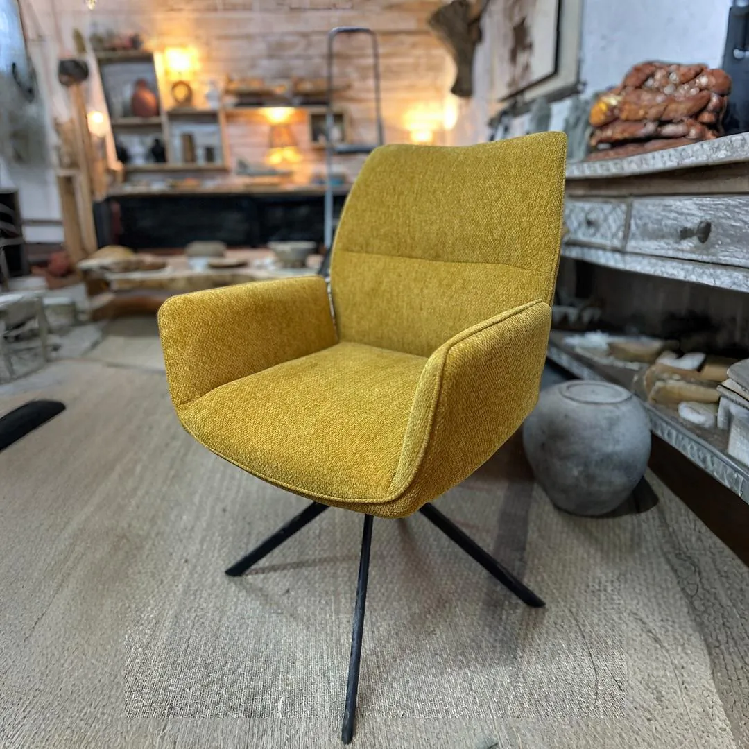 Fauteuil jaune moutarde dans salon rustique.