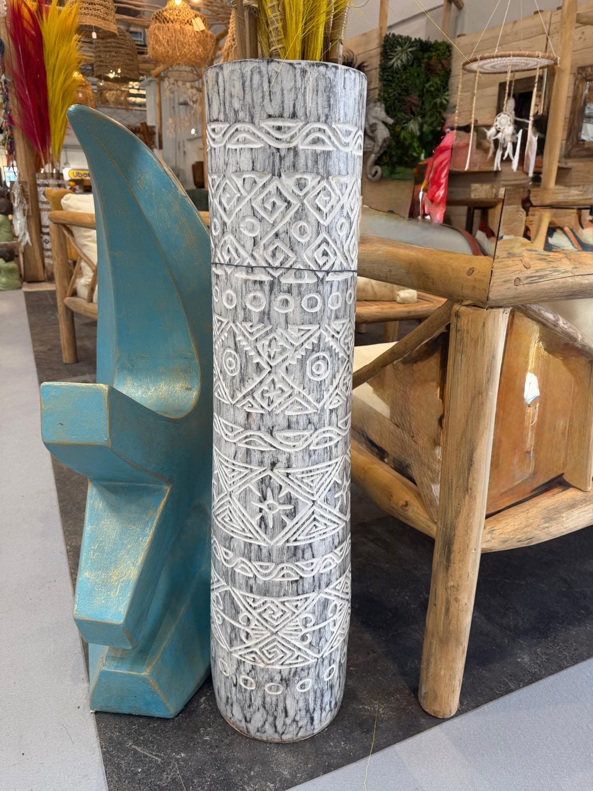 Vase en bois sculpté avec motifs ethniques.