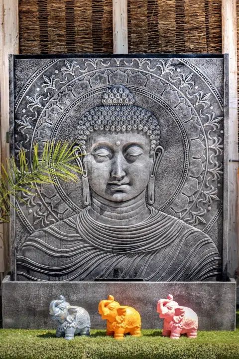 Relief de Bouddha avec éléphants colorés devant.